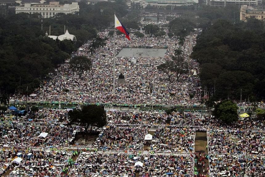 A handout photo provided by the Philippine Air Force Public Information Office (PAF-PIO) shows aerial shot of devotees during a downpour of rain waiting for the arrival of Pope Francis to celebrate a mass at the Rizal park in Manila, Philippines, on 