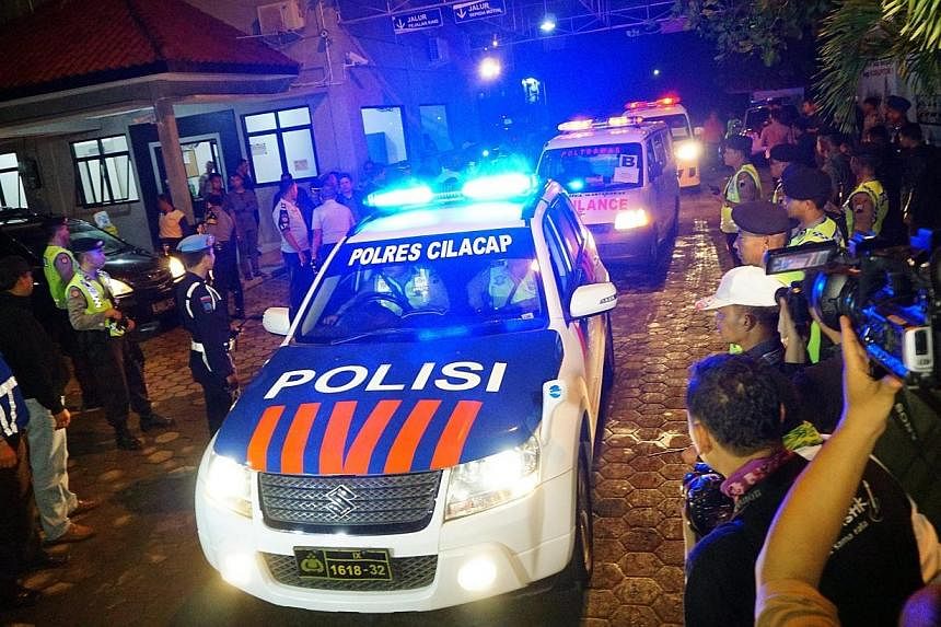 An Indonesian police car leads ambulances carrying the bodies of five prisoners out of Wijayapura port as they arrived from Nusakambangan Island prison complex, after their execution under the death row for drug trafficking, in Cilacap, Central Java,