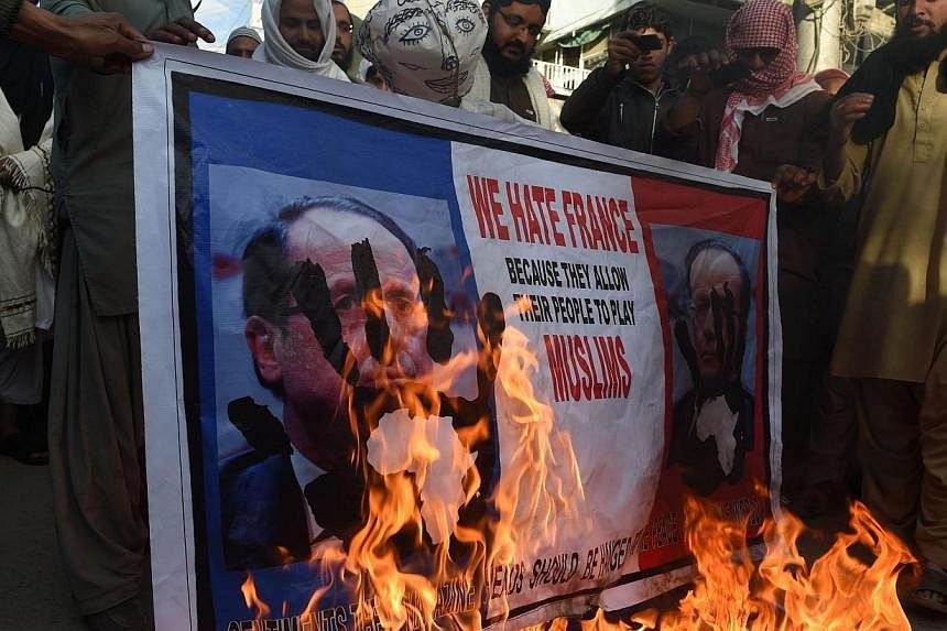 Pakistani protesters burn a poster featuring a portrait of French President Francois Hollande during a protest against the printing of satirical sketches of the Prophet Muhammad by French magazine Charlie Hebdo, in Quetta on Jan 18, 2015.Thousands of