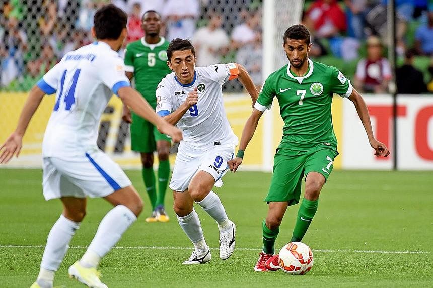 Salman Alfaraj (right) of Saudi Arabia in action against Odil Akhmedov (centre) of Uzbekistan during their AFC Asian Cup Group B soccer match at the Melbourne Rectangular Stadium in Melbourne, Australia on Jan 18, 2015.&nbsp;Uzbekistan booked a place