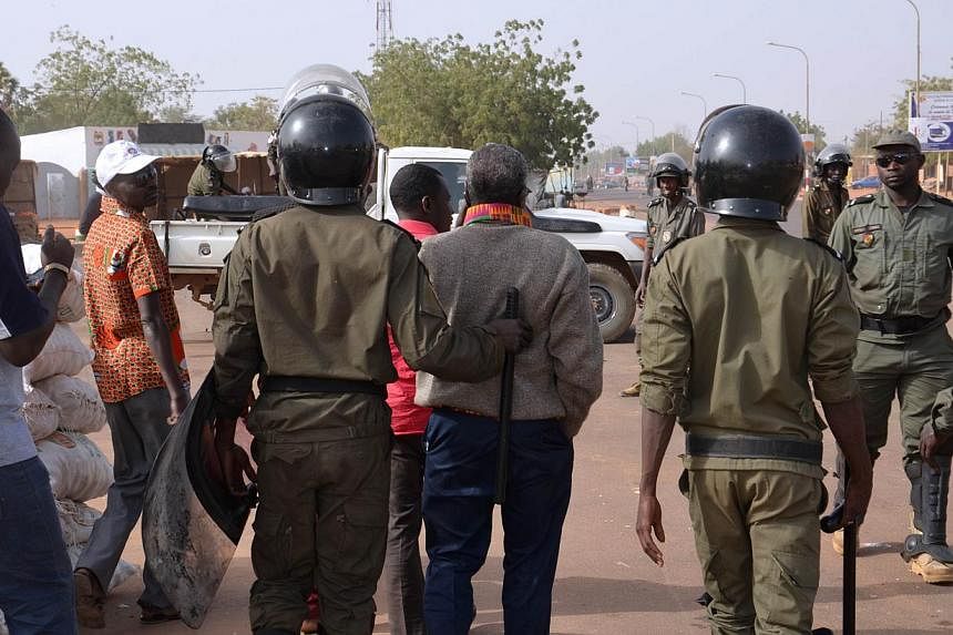 Police officers walk next to protesters as they disperse a banned opposition demonstration in the Nigerien capital Niamey on Jan 18, 2015, a day after deadly riots erupted over publication by France's Charlie Hebdo magazine of a cartoon depicting Isl