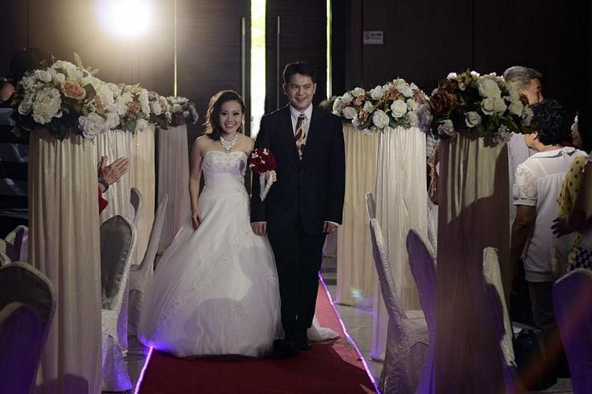 Newlyweds Gideon Tan and Rebecca Goh (both above) held their wedding at Pekin Restoran Johor Jaya restaurant in Johor Baru and chartered two buses to the tune of $1,400 to ferry their family and friends across the Causeway. --&nbsp;PHOTO: COURTESY OF