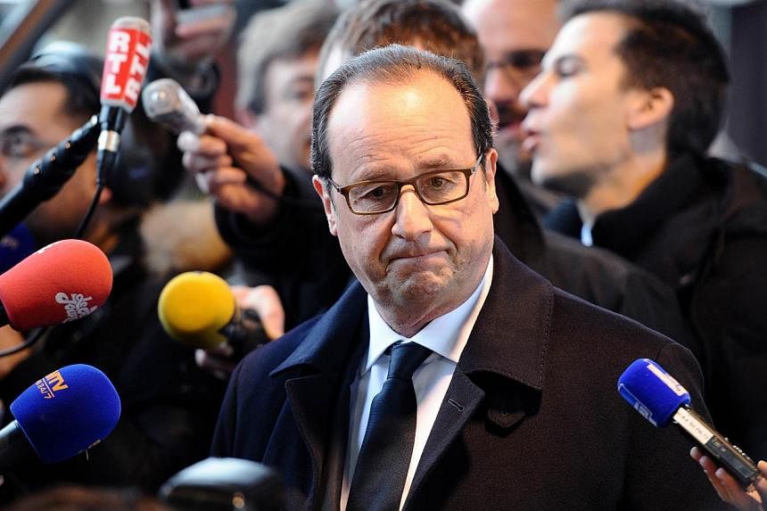French President Francois Hollande (centre) stands next to journalists as he visits a market in Tulle on Jan 17, 2015. Hollande stressed that France had "principles, values, notably freedom of expression" after violent protests against the satirical 
