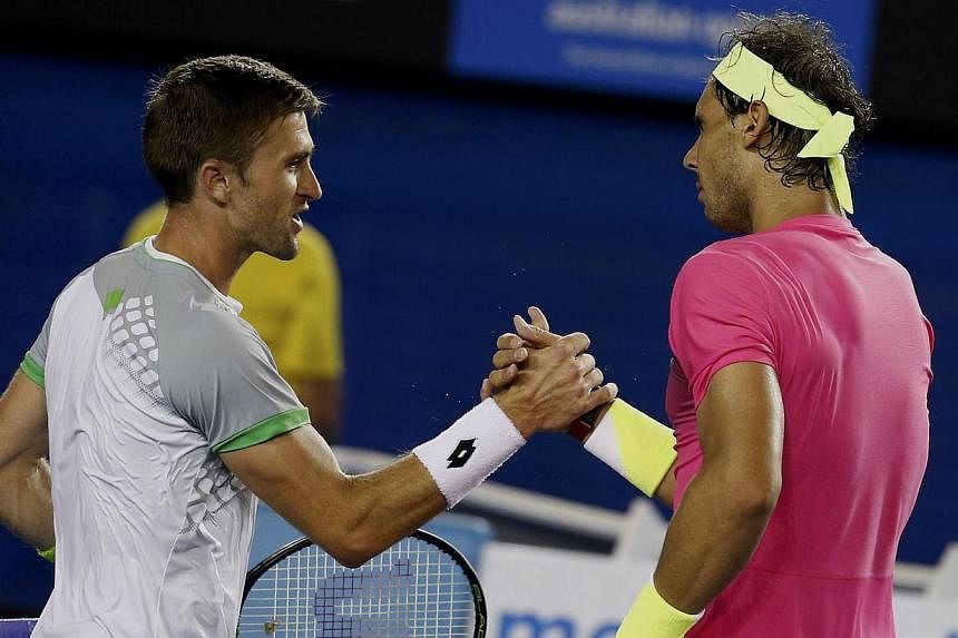 Rafael Nadal (right) of Spain shakes hands with Tim Smyczek of the US after defeating him in a gruelling five-setter during their men's singles second round match at the Australian Open 2015 tennis tournament in Melbourne on Jan 21, 2015. -- PHOTO: R