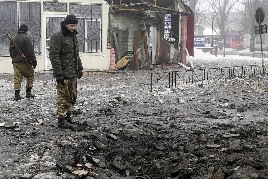 Ukrainian servicemen look at the craters from the shells at the central street of Debaltsevo, Ukraine on Jan 20, 2015.&nbsp;Russia is boosting its troop presence in eastern Ukraine and attacks from separatist rebels have intensified as they seek to g