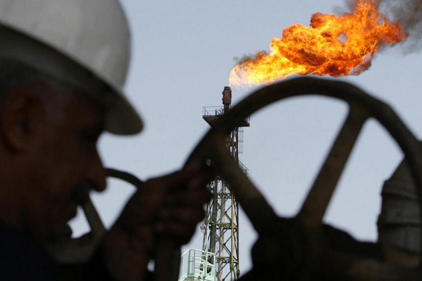 An Iraqi worker opens a pipe at Sheaiba oil refinery in Basra in this Mar 29, 2007.&nbsp;Oil prices are unlikely to fall further after a plunge of nearly 60 per cent since June, Iraqi Oil Minister Adel Abdul Mahdi said on Wednesday. -- PHOTO: REUTERS