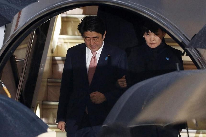Japan's Prime Minister Shinzo Abe (left) and his wife Akie disembark from a plane as they arrive at Haneda airport in Tokyo on Jan 21, 2015. Mr Abe said on Wednesday the government was in a "race against time" to save two Japanese nationals held host
