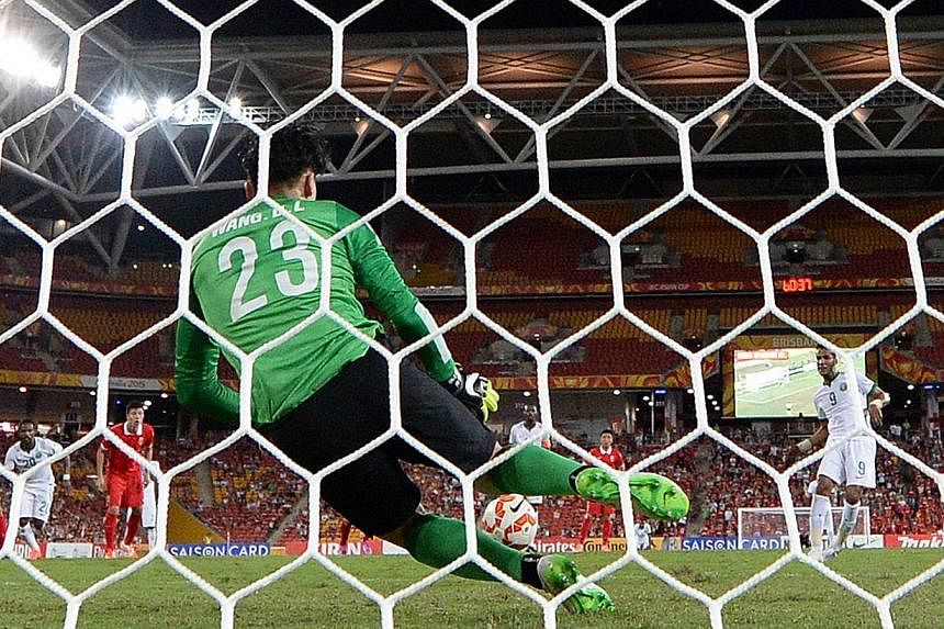 China"s goal keeper Wang Dalei (left) saves a penalty from Saudi player Naif Hazazi during the Group B Asian Cup match between the Kingdom of Saudi Arabia and the People's Republic of China at Brisbane Stadium in Brisbane, Australia, Saturday, Jan 10