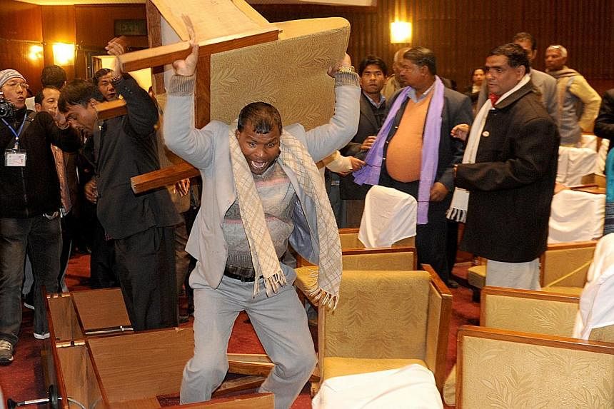 A&nbsp;Nepalese constituent assembly member breaks a chair as tensions flare at a Parliament session in Kathmandu on Jan 20, 2015. The country's Maoist chief apologised on Wednesday, Jan 21, for his party's part in the scuffle that injured four secur