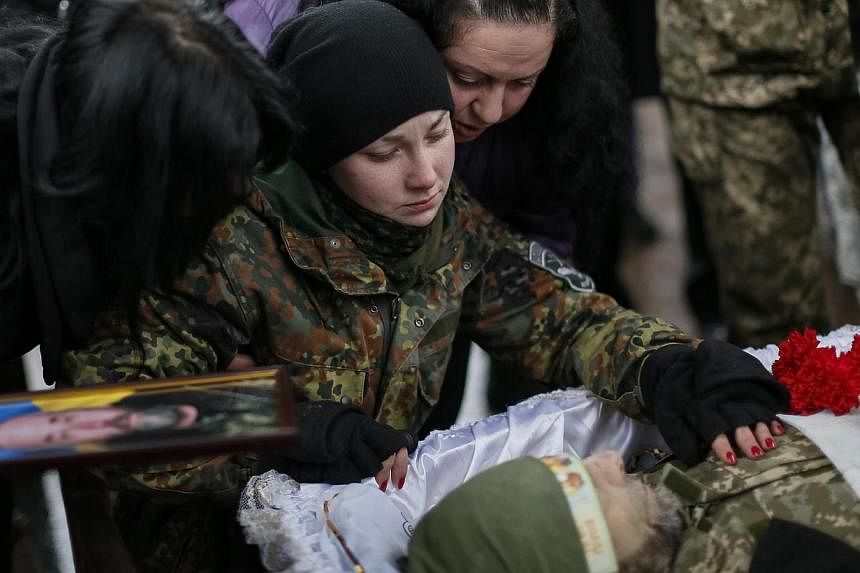 A woman reacting during a funeral ceremony for her father, a serviceman killed during fighting in the Lugansk region in eastern Ukraine, at Independence Square in central Kiev, Jan 20, 2015.&nbsp;Ukraine on Tuesday accused Russian forces of attacking