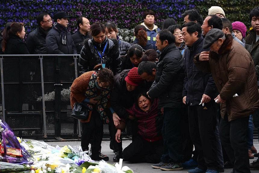 Family members mourning on Jan 6, 2015, for the victims of a new year's eve stampede at &nbsp;Shanghai's historic riverfront. -- PHOTO: AFP