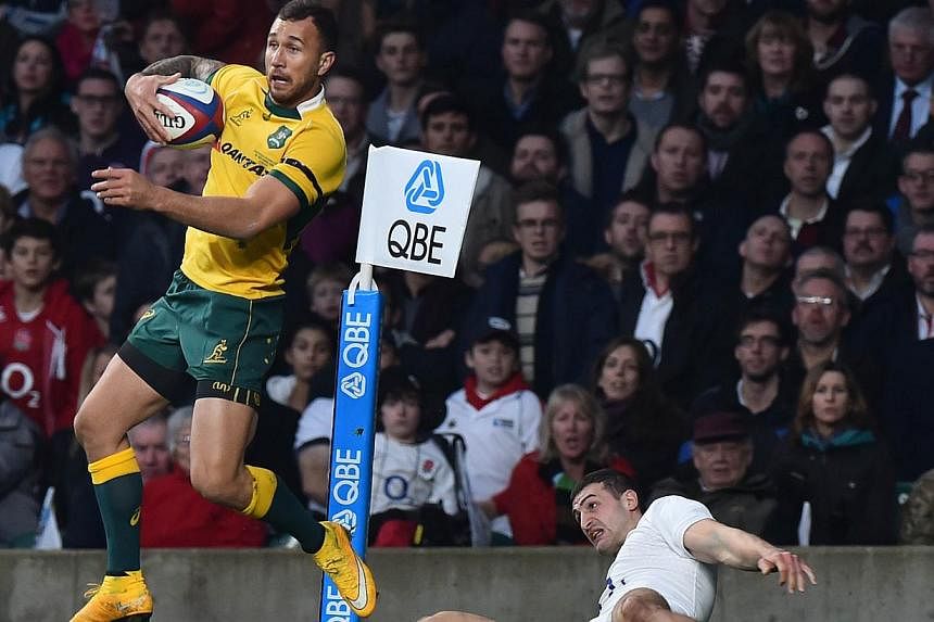Australia's Quade Cooper (left) wins the ball from England's wing Jonny May (right) during the Autumn International rugby union Test match between England and Australia at Twickenham Stadium, southwest of London on Nov 29, 2014. Wallaby fly-half Quad