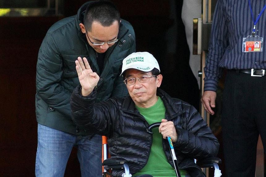 Former Taiwan president Chen Shui-bian (centre) waves to supporters as he is escorted by his son Chen Chih-chung (left) after being freed from prison in Taichung on Jan 5, 2015.&nbsp;Taiwanese prosecutors on Friday indicted convicted former president