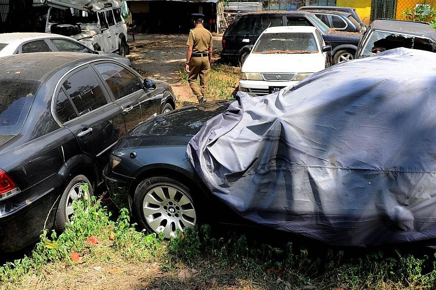 A Sri Lankan police officer walks through a vehicle yard found in the capital Colombo on Jan 23, 2015.&nbsp;Sri Lanka's police Friday seized a fleet of more than 50 state-owned vehicles, including bullet-proof limousines, that were not returned after