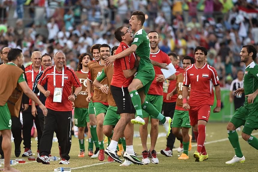Dhurgham Ismael of Iraq (centre) celebrates scoring a penalty goal in extra time against Iran during their AFC Asian Cup quarter-final football match in Canberra on Jan 23, 2015. Iraq beat Iran 7-6 on penalties to reach the semi-finals of the Asian C