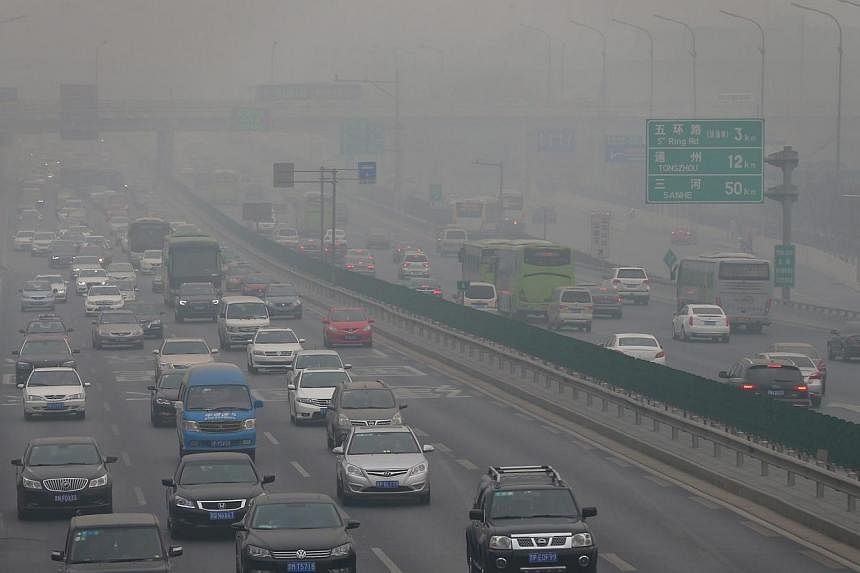 Vehicles go through a main thoroughfare while the PM2.5 Air Quality Index (AQI) reaches more than 500 in Beijing city, China, on Jan 15, 2015. -- PHOTO: EPA