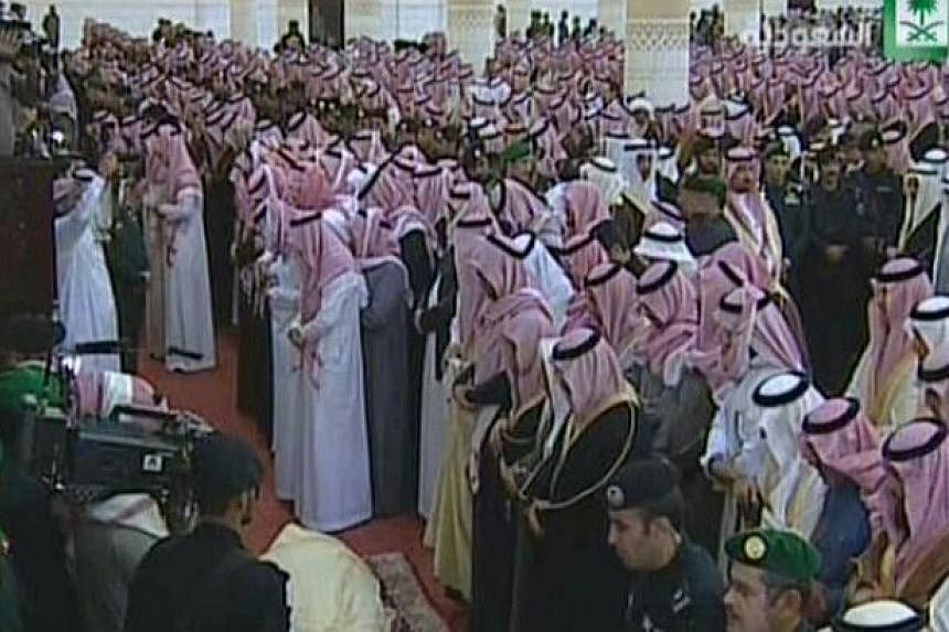 An image grab taken from Saudi state TV on Jan 23, 2015 shows mourners around the body of Saudi King Abdullah bin Abdul Aziz during his funeral procession at Imam Turki Bin Abdullah Grand Mosque in Riyadh. -- PHOTO: AFP