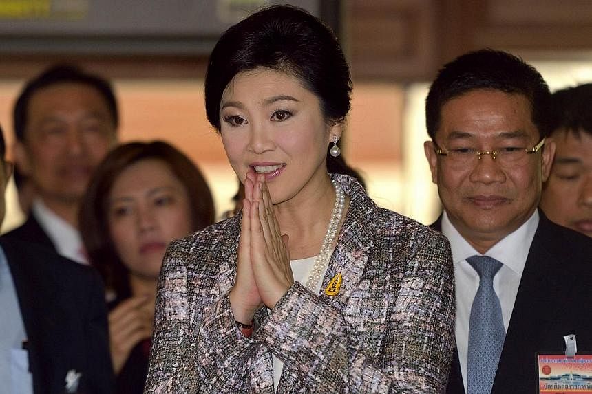 Ousted Thai prime minister Yingluck Shinawatra (centre) gestures a traditional greeting to members of the media prior to facing impeachment proceedings by the military-stacked National Legislative Assembly (NLA) at the parliament in Bangkok on Jan 22