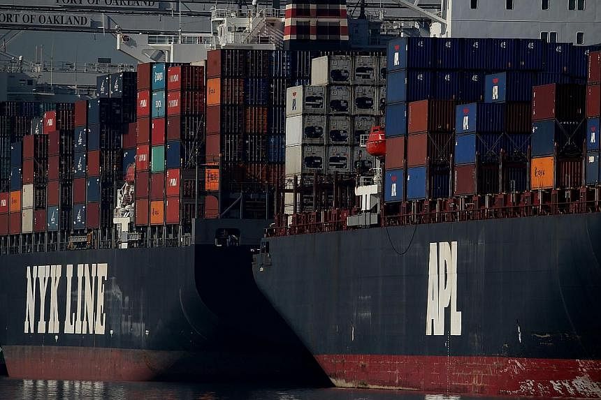 Container ships docked at the Port of Oakland on Jan 7, 2015 in Oakland, California. KFC Japan is the &nbsp;latest casualty of the french fries shortage caused by a US West Coast dock workers' contract dispute. -- PHOTO: AFP