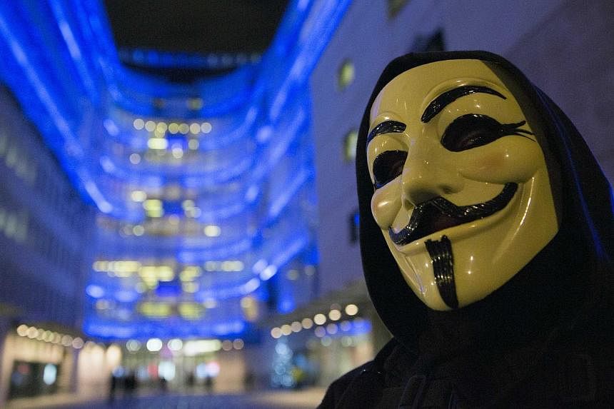 A supporter of the activist group Anonymous wearing a mask associated with the group on Dec 23, 2014. A journalist also known as an informal spokesman for the hacker group Anonymous was sentenced to five years in prison on Thursday in a case which ra