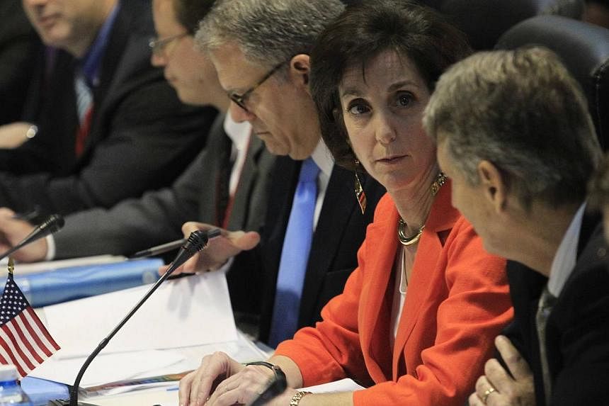 US assistant secretary of state&nbsp;Roberta Jacobson (orange jacket) talks to deputy assistant secretary of state Alex Lee (second right) during negotiations to restore diplomatic ties with Cuba in Havana Jan 22, 2015. -- PHOTO: REUTERS