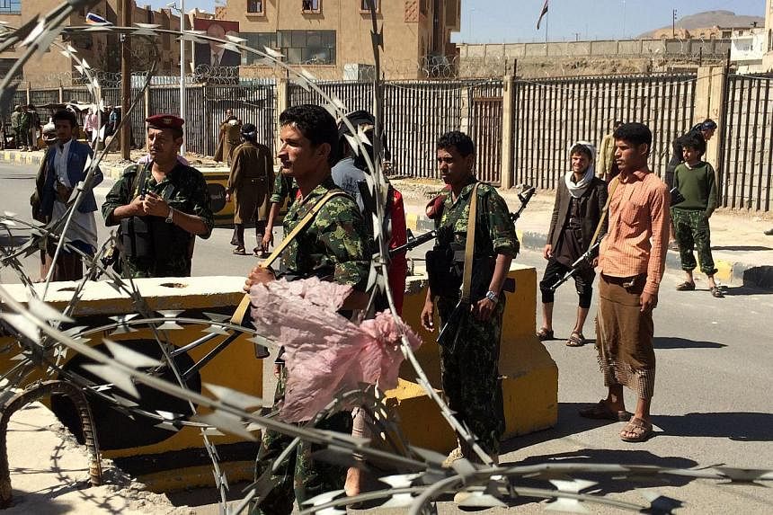 Shi'ite Huthi militiamen wearing uniforms confiscated from the Yemeni army stand at a barrier in the area around the house of the country's President in the capital Sanaa, on Jan 22, 2015. -- PHOTO: AFP
