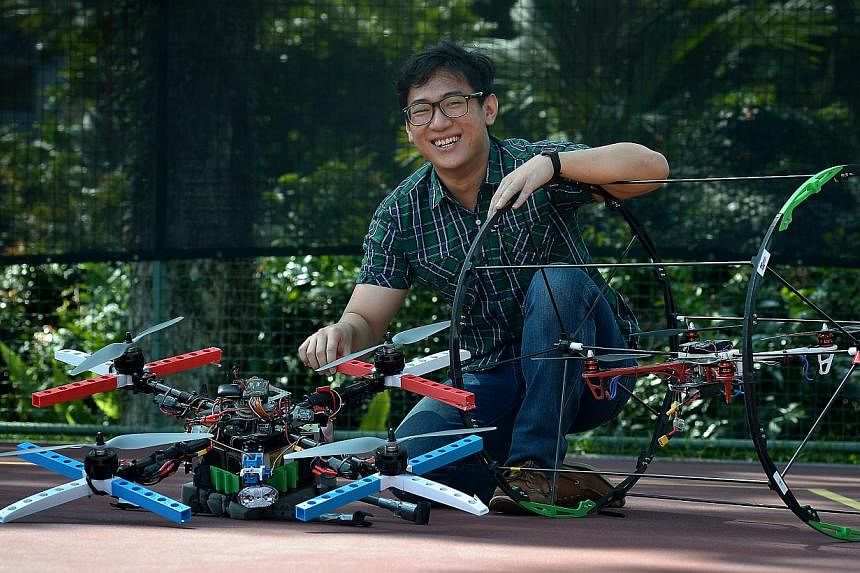 NUIS student Jonathan Chua, 25, with two variations of the multi-purpose quadcopter developed by his team. When a roll cage (right) is snapped on, it can roll on the ground and enter buildings to give aid or reconnoitre.