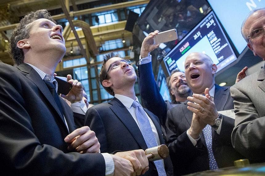 Box co-founder and chief executive Aaron Levie (left) and co-founder and chief financial officer Dylan Smith (second left) ring a ceremonial bell during their company's IPO on the floor of the New York Stock Exchange Jan 23, 2015. -- PHOTO: REUTERS