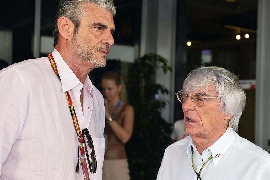 Ferrari new team chief Maurizio Arrivabene (left) talking with F1 supremo Bernie Ecclestone (right) in the pits of the Abu Dhabi track on Nov 23, 2014. -- PHOTO: AFP