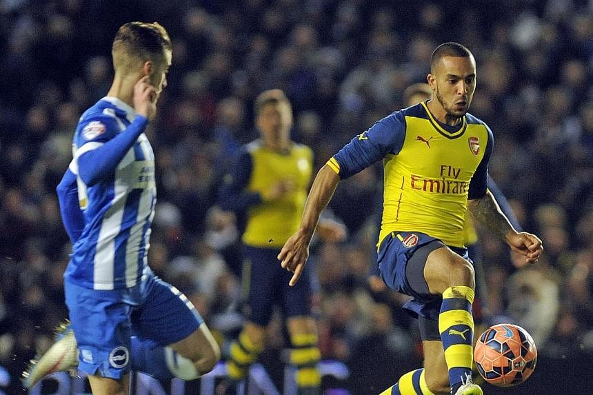 Arsenal's Theo Walcott (right) in action against Brighton's Joe Bennett during the FA Cup fourth round at the American Express Community Stadium in Brighton on Jan 25 2015. -- PHOTO: EPA