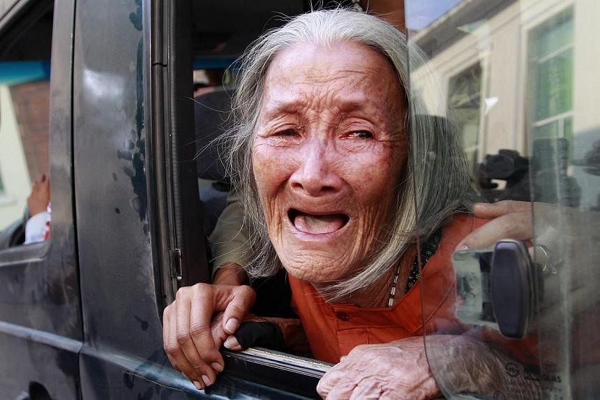 Cambodian woman Nget Khun, 75, crying at a police van window at the appeals court in Phnom Penh, Cambodia on Jan 26, 2015.&nbsp;-- PHOTO: EPA