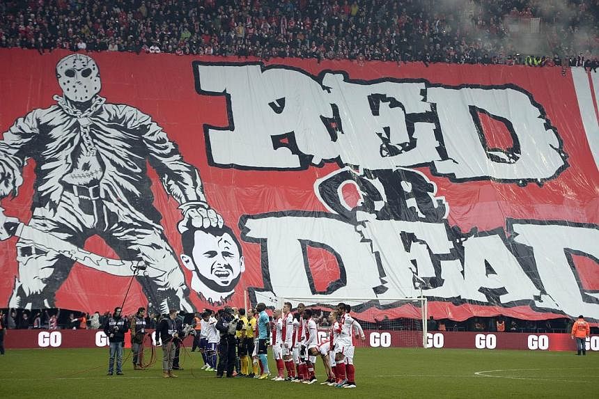 Standard de Liege fans display a banner depicting the decapitation of their former captain and current Anderlecht midfielder Steven Defour on Jan 25, 2015. -- PHOTO: AFP