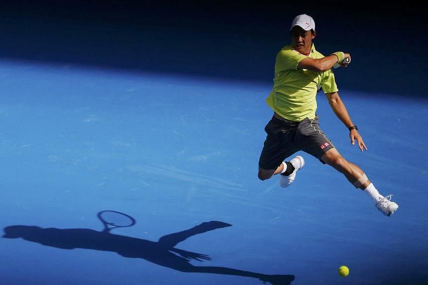 Kei Nishikori of Japan casts a shadow as he hits a return to David Ferrer of Spain during their men's singles fourth round match at the Australian Open 2015 tennis tournament in Melbourne on Jan 26, 2015.&nbsp;-- PHOTO: REUTERS
