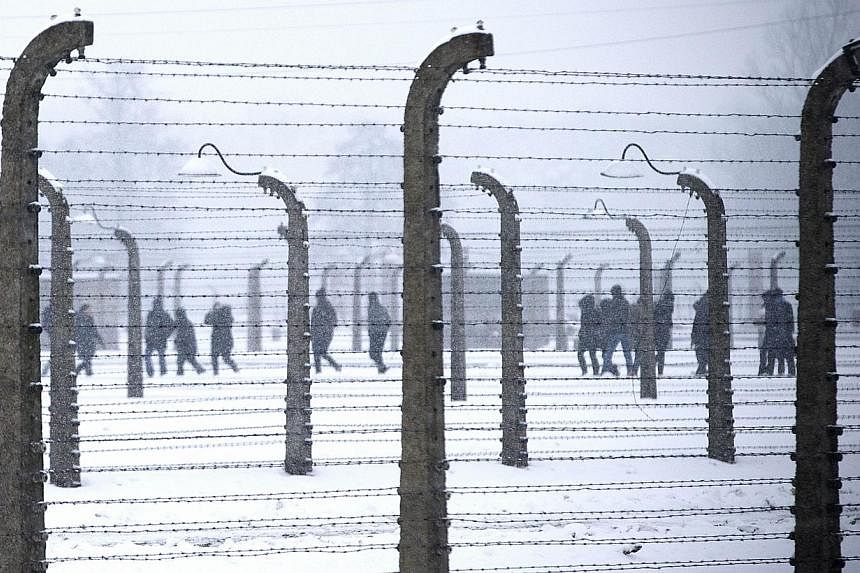 Visitors walk inside former Nazi concentration camp Auschwitz-Birkenau in Oswiecim, Poland on Jan 25, 2015, days before the 70th anniversary of the liberation of the camp by Russian forces. -- PHOTO: AFP