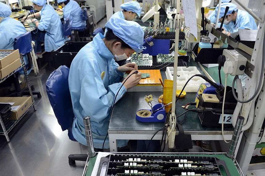 Workers at Add-Plus, an electronics manufacturing company that makes printed circuit boards. -- ST PHOTO: DESMOND FOO