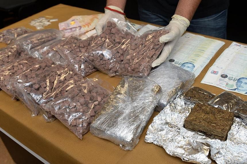 Drugs and over $12,000 cash found during a raid on an alleged drug syndicate by Central Narcotics Bureau in September 2014. -- PHOTO: ST FILE