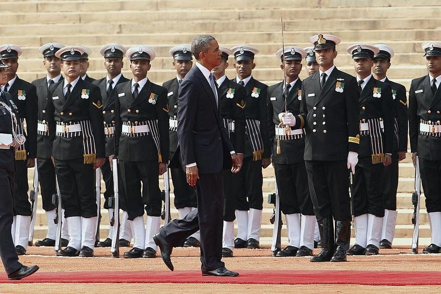 US President Barack Obama (centre) walks on a red carpet as he inspects a guard of honor during his welcoming ceremony at the Indian president's house in New Delhi, India, on Jan 25, 2015. -- PHOTO: EPA