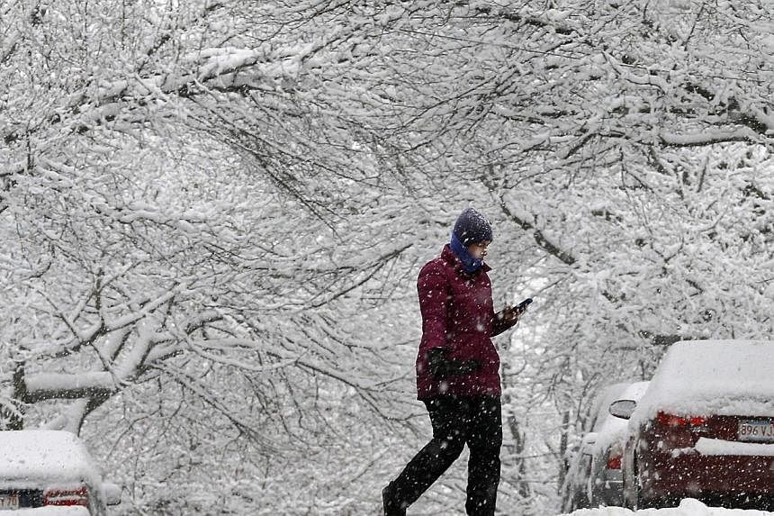 A woman crosses a road during a winter snowstorm in Somerville, Massachusetts over the weekend. The US Northeast, including New York and Boston, is bracing for a &nbsp;snowstorm that may be of historic proportions starting today, the National Weather
