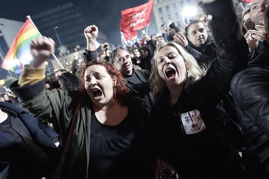Anti-austerity Syriza party supporters celebrating as leader Alexis Tsipras speaks folllowing victory in the election in Athens on Jan 25, 2015. -- PHOTO: AFP