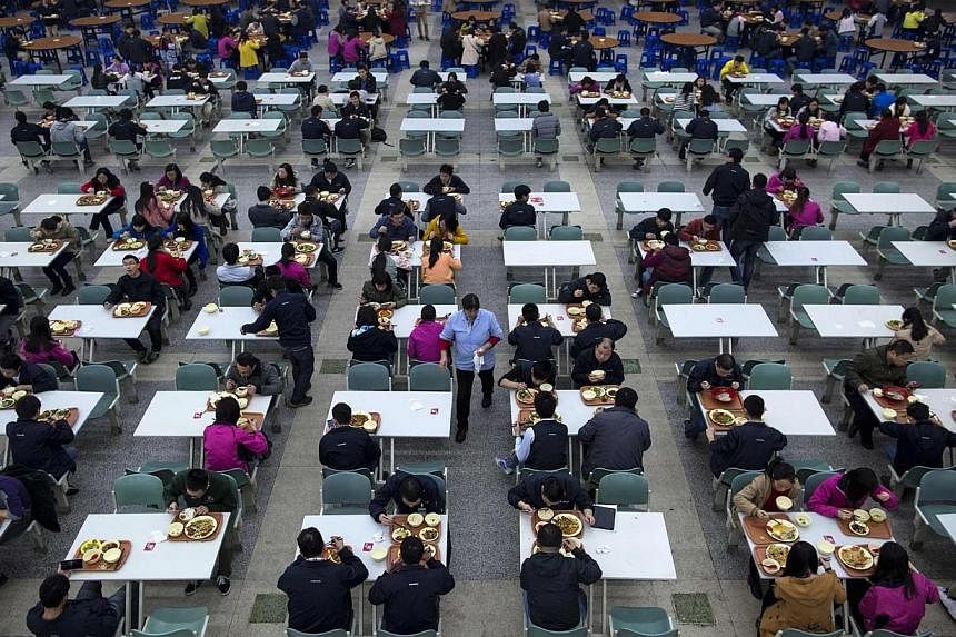 Workers eating their lunch at a restaurant inside a Foxconn factory in the township of Longhua in Shenzhen, Guangdong province on Jan 21, 2015. -- PHOTO: REUTERS