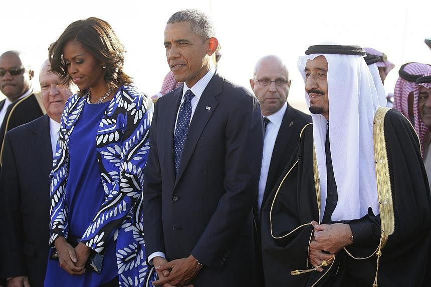 US President Barack Obama and first lady Michelle Obama are greeted by Saudi Arabia's King Salman (right) as they arrive at King Khalid International Airport in Riyadh, on Jan 27, 2015.&nbsp;US President Barack Obama landed in Saudi Arabia on Tuesday