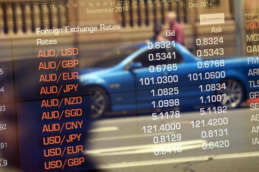 Australian Securities Exchange boards showing the local dollar in Sydney on Dec 8, 2014. Many of UBS' wealthiest Asian clients have begun to abandon the Australian dollar as the country's bond yield premium over the US' slid and the Federal Reserve d