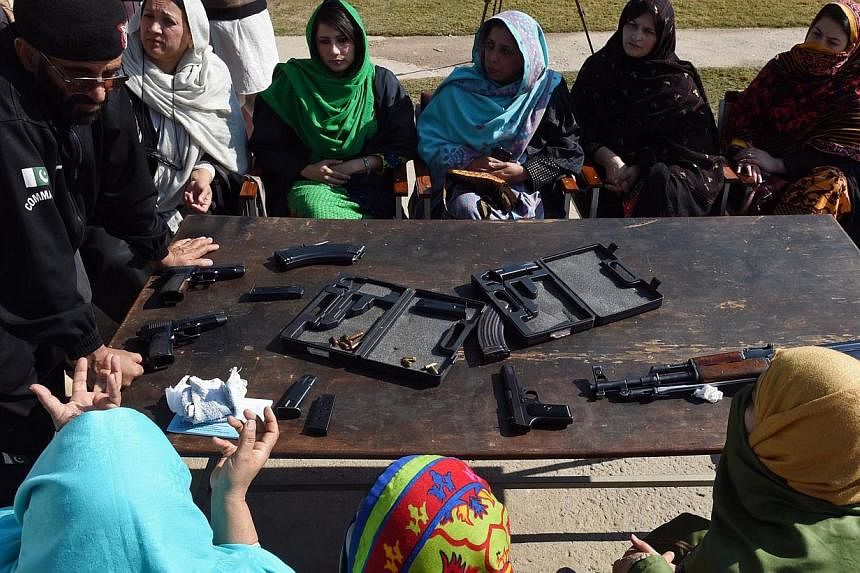 A Pakistani Anti Terrorist Squad (ATS) police official displays various types of firearms during a weapons training session for school, college and university teachers in Peshawar on Jan 27, 2015. -- PHOTO: AFP