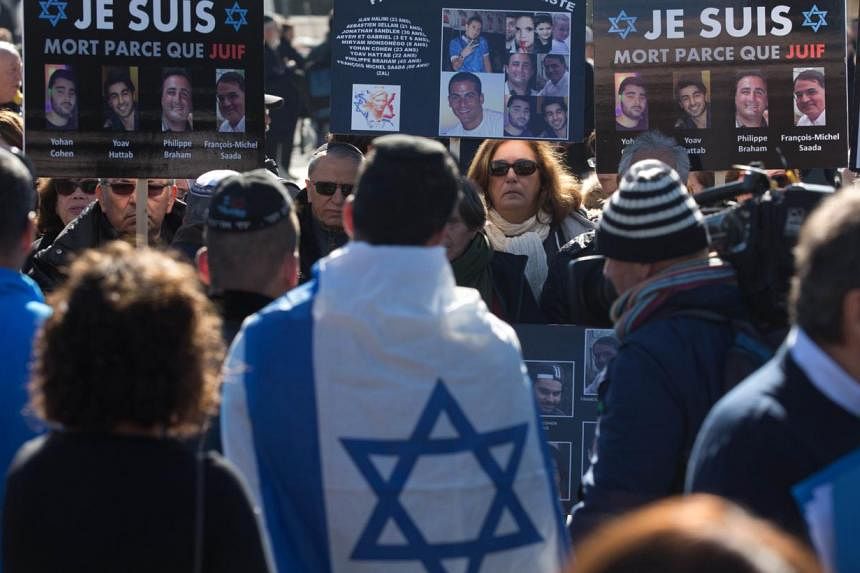 Mourners carry placards bearing portraits of the victims as they gather at a cemetery in Jerusalem on Jan 13, 2015 during the funeral of four Jews killed in an Islamist attack on a kosher supermarket in Paris. The number of anti-Semitic acts doubled 