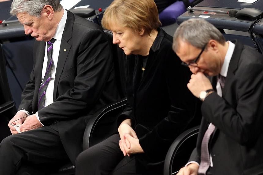 German President Joachim Gauck (left), German Chancellor Angela Merkel (centre) and the President of the Federal Constitutional Court of Germany, Andreas Vosskuhle, attend a commemorative session of the German 'Bundestag' parliament in Berlin on Jan 