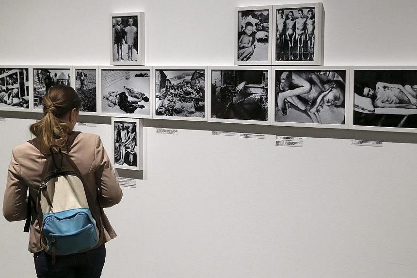 A visitor looks at photos of an exhibition dedicated to the 70th anniversary of liberating the Nazi concentration camp Auschwitz at the Jewish Museum and Tolerance Center in Moscow, Russia on 27 Jan 2015. International Holocaust Remembrance Day this 