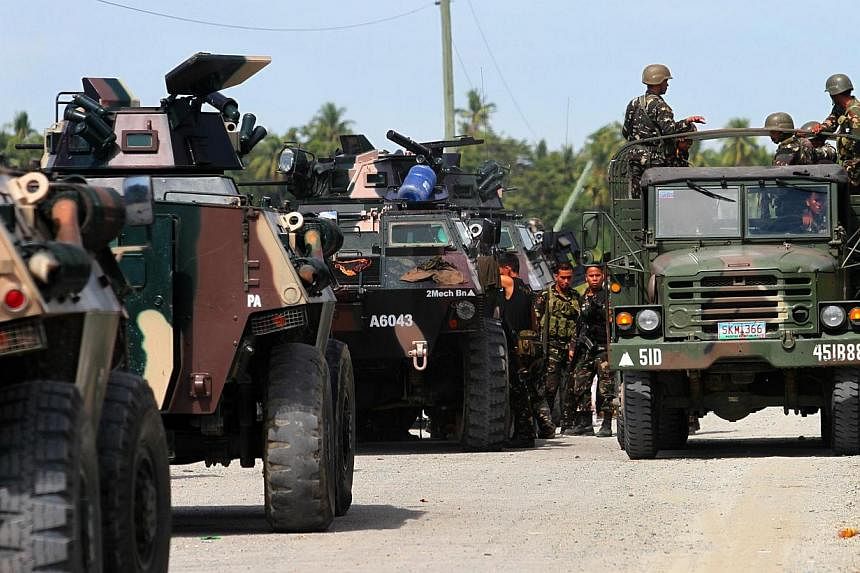 Philippine military personnel on a lorry going past armoured personnel carriers along the highway in the town of Mamasapano, on Mindanao, on Jan 26, 2015. There is a "high likelihood" that a Malaysian militant suspected of being behind the 2002 Bali 