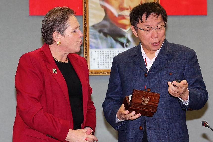 Taipei Mayor Ko Wen-je (right) receives a gift of a watch from visiting British Transport Minister Susan Kramer during a meeting in Taipei on Jan 26, 2015. Taipei mayor Ko Wen-je landed himself in hot water on Monday when he joked that the watch pres