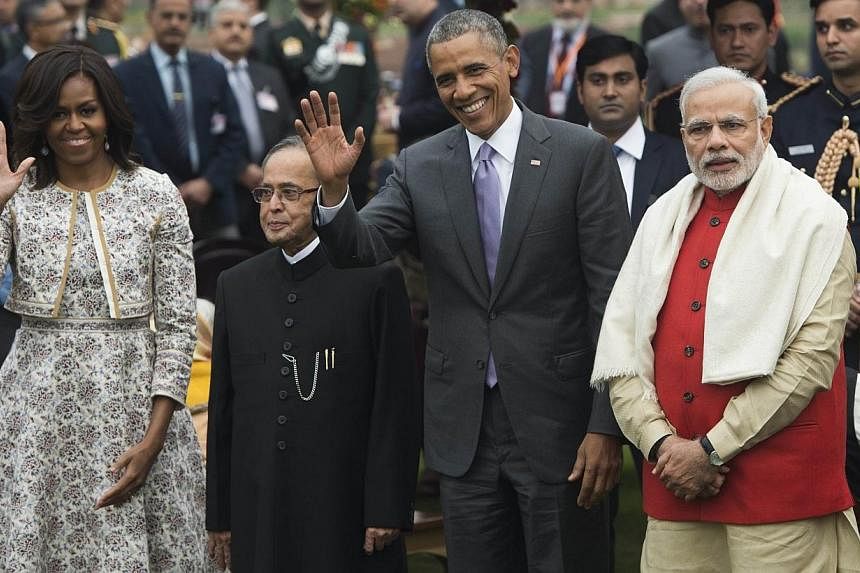 US President Barack Obama (second from right), Indian Prime Minister Narendra Modi (right), Indian President Pranab Mukherjee (second from left) and First Lady Michelle Obama (left) wave during a reception at Rashtrapati Bhawan, the Presidential Pala