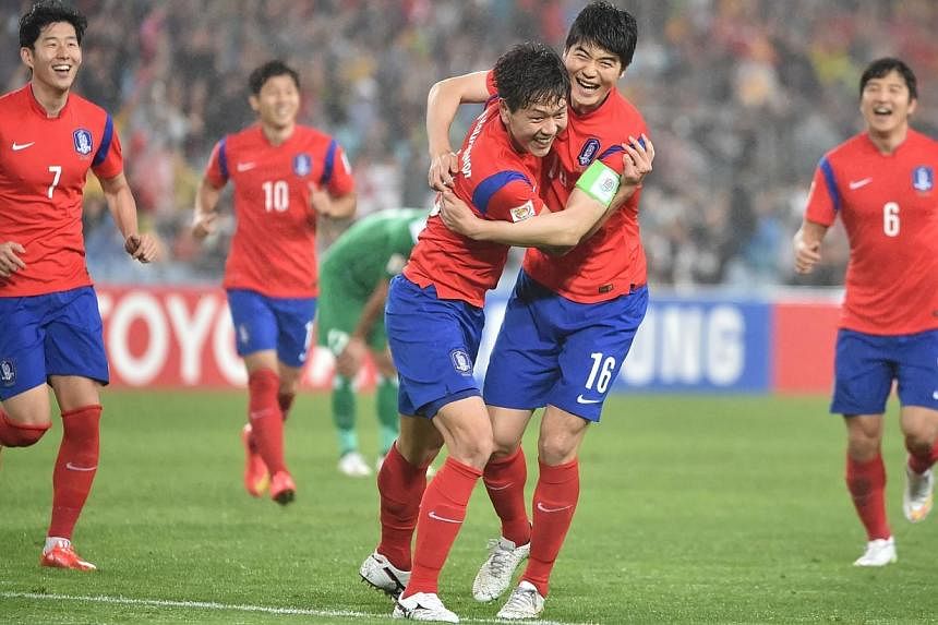 Kim Young Gwon of South Korea (centre left) celebrates scoring their second goal with captain Ki sung Yueng (centre right) against Iraq during the AFC Asian Cup semi-final football match in Sydney on Jan 26, 2015. -- PHOTO: AFP